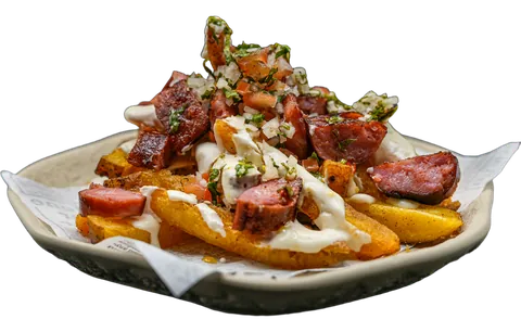 Salchipapa: batata frita com rodelas de chouriço crioulo, molho de queijo creme, chimichurri e pico de gallo.